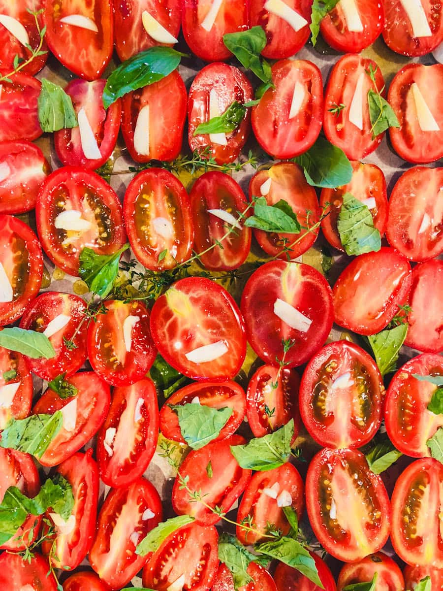 tomates en demies sur plaque avec huile et herbes