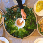 plateau de fines herbes fraîches et crêpes dorées banh xeo sur la table