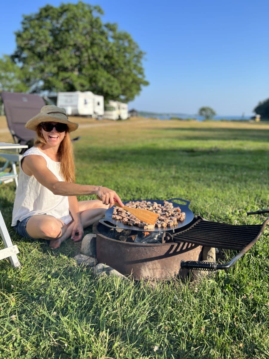 Manon Lapierre cuisine sur le feu en camping