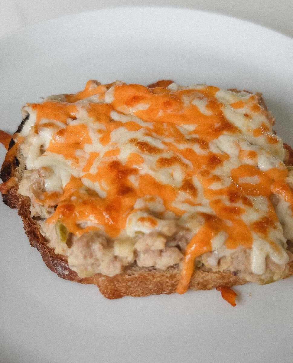croque au thon au fromage orange et jaune fondu dans une assiette blanche