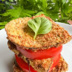 aubergine parmigiana air fryer, tranches d'aubergines panées entre tranches de tomates, garni d'une feuille de basilic
