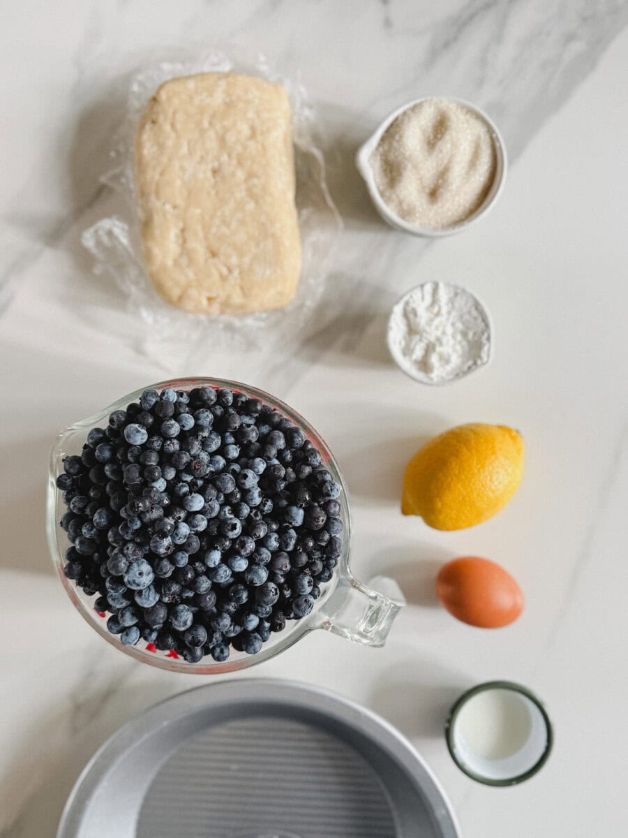 ingrédient pour tarte aux bleuets sur comptoir marbré blanc