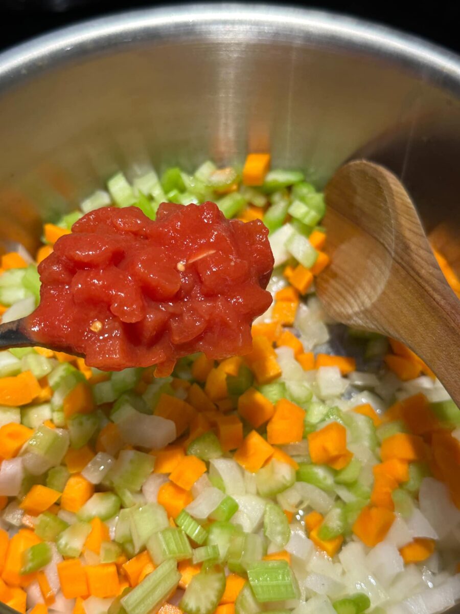 tomate en morceaux en conserve avec céleri, carottes, oignon dans une casserole