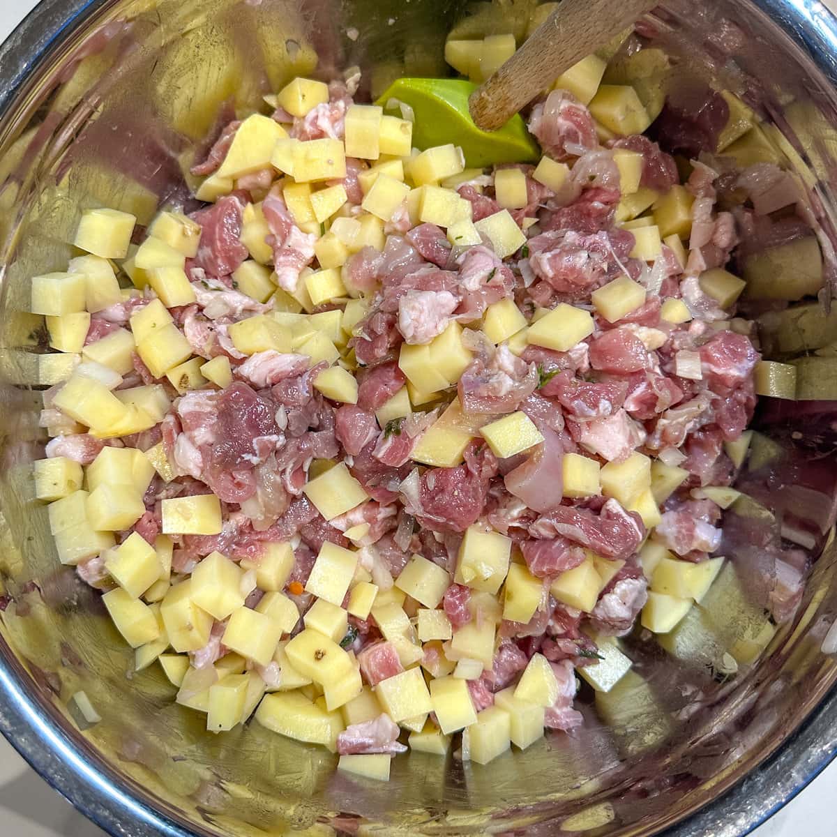 farce à tourtière: pommes de terre, viandes, herbes dans un bol en stainless