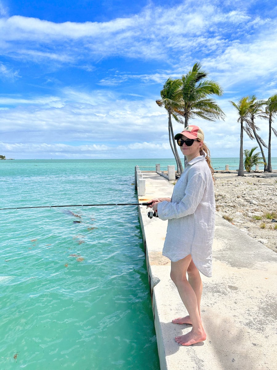 petite bette (Manon Lapierre) à la pêche dans les Keys en Floride sur un quai devant océan turquoise