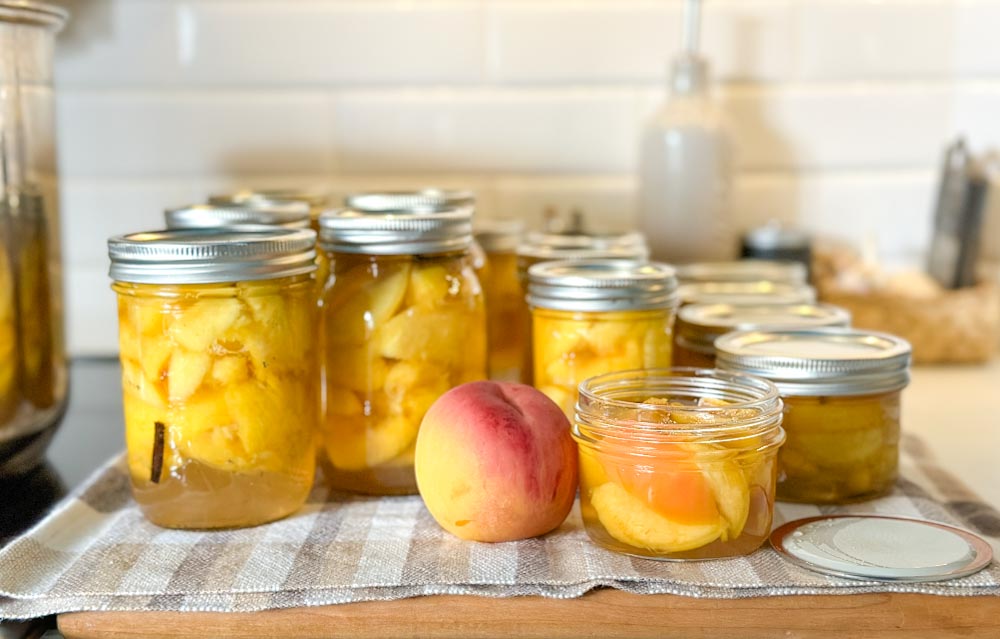 pot de conserve de pêches dans le sirop sur une planche