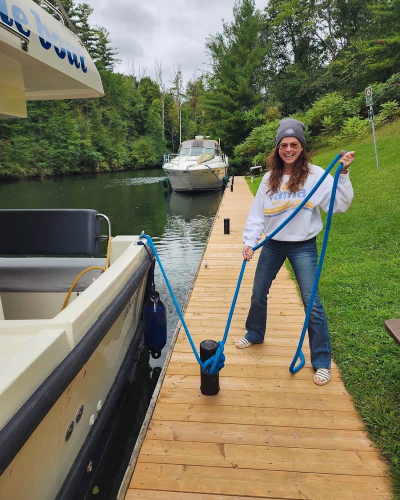 Manon Lapierre sur un quai tenant les cordages de bateau