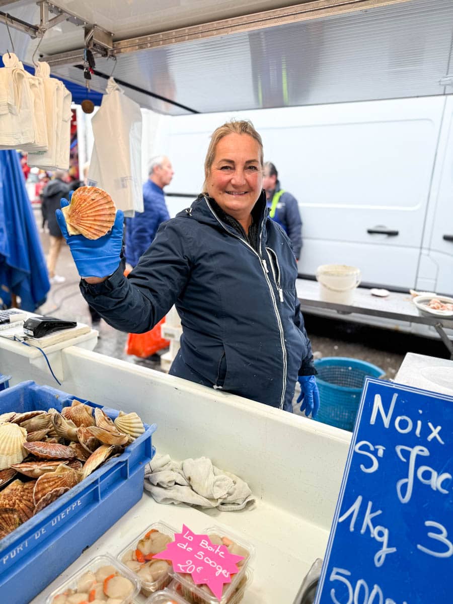 femme avec coquille saint-jacques dans la maison au marché de poisson