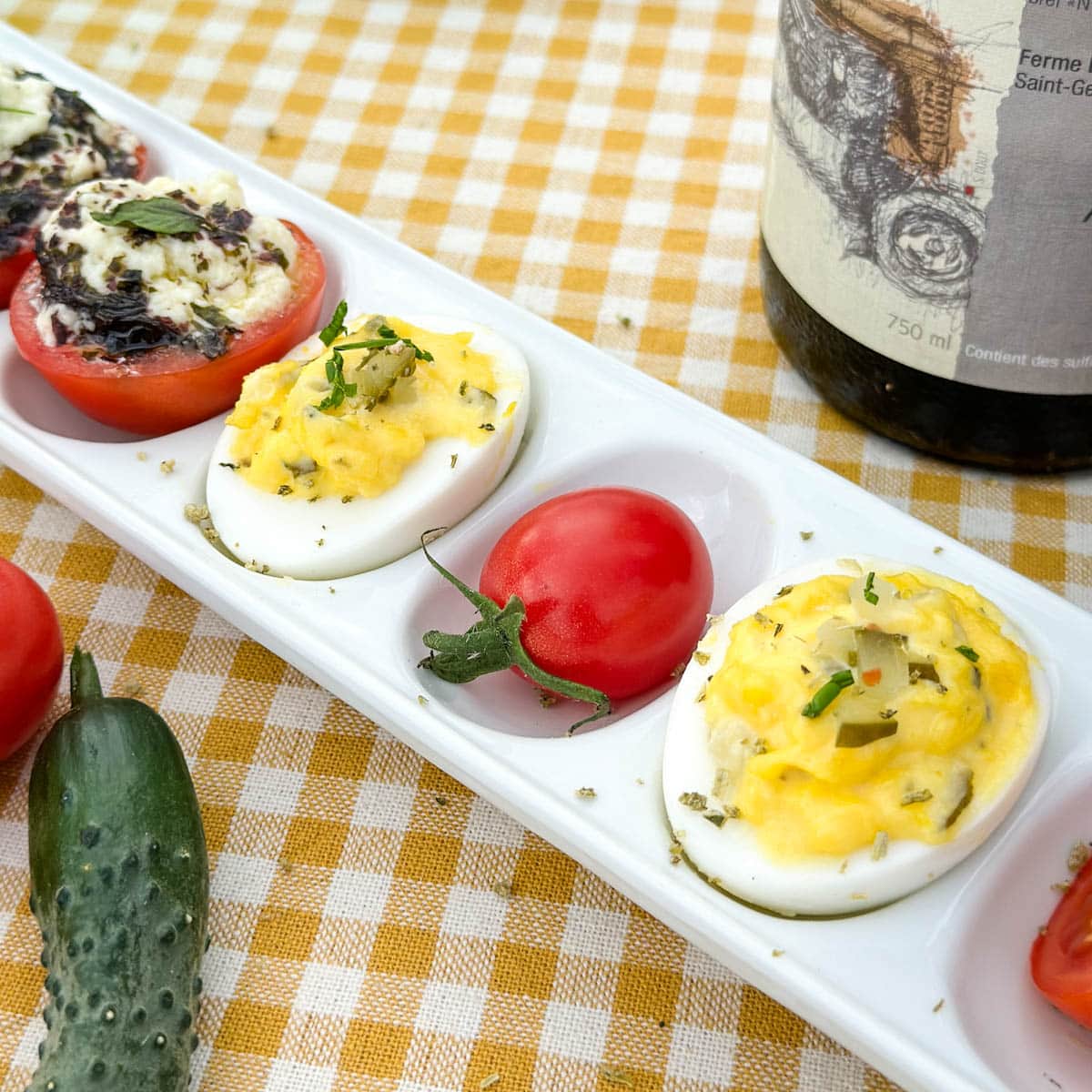 oeufs farcis mimosa dans un plat de service avec tomates cerise