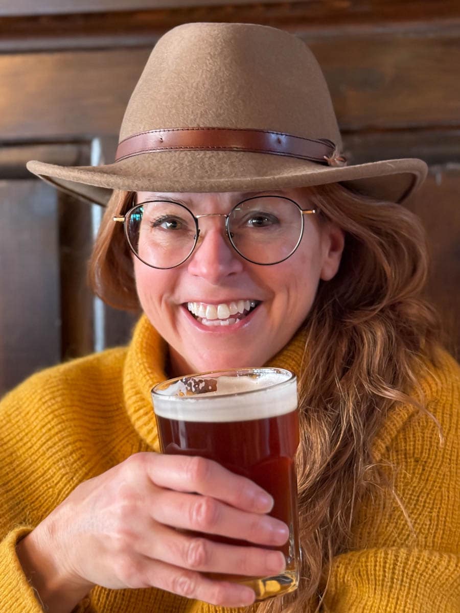 Manon Lapierre avec un verre de bière dans la main et un chapeau sur la tête