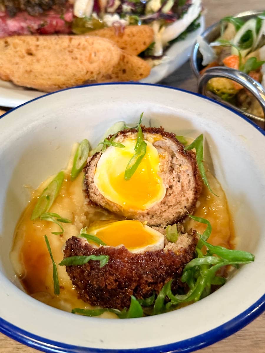 oeuf écossais avec jaune coulant dans un bol