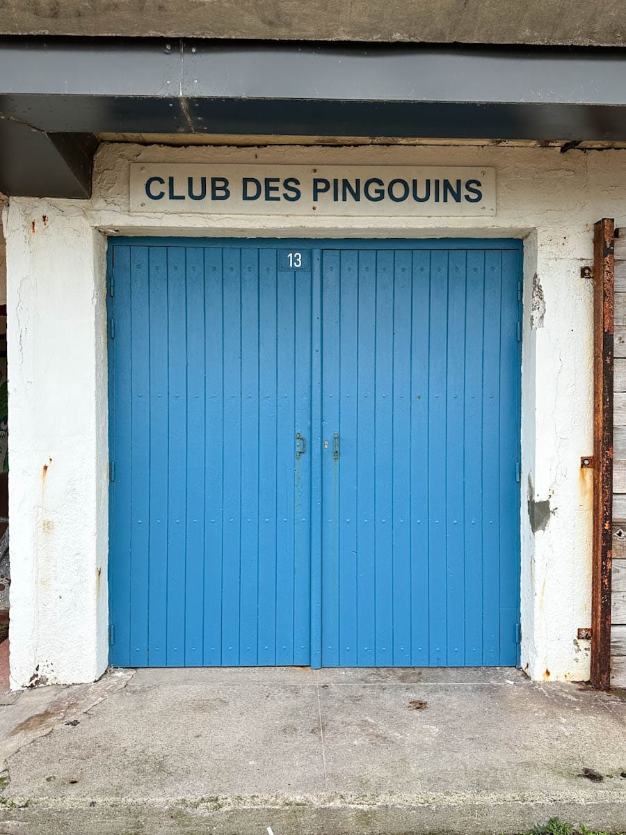 portes bleus marqué Le club des Pingouins à la plage de Dieppe