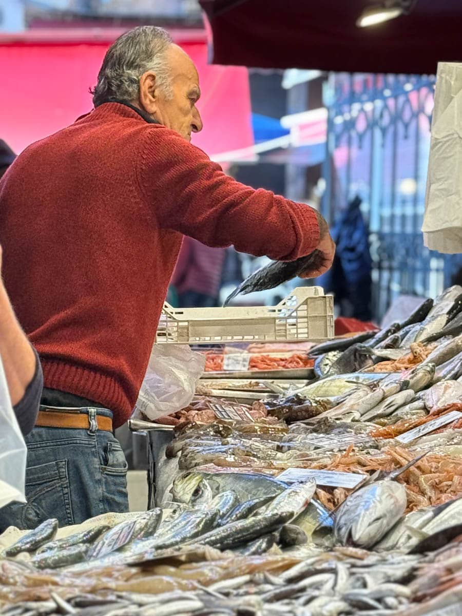 marchand de poisson dans marché en Sicile