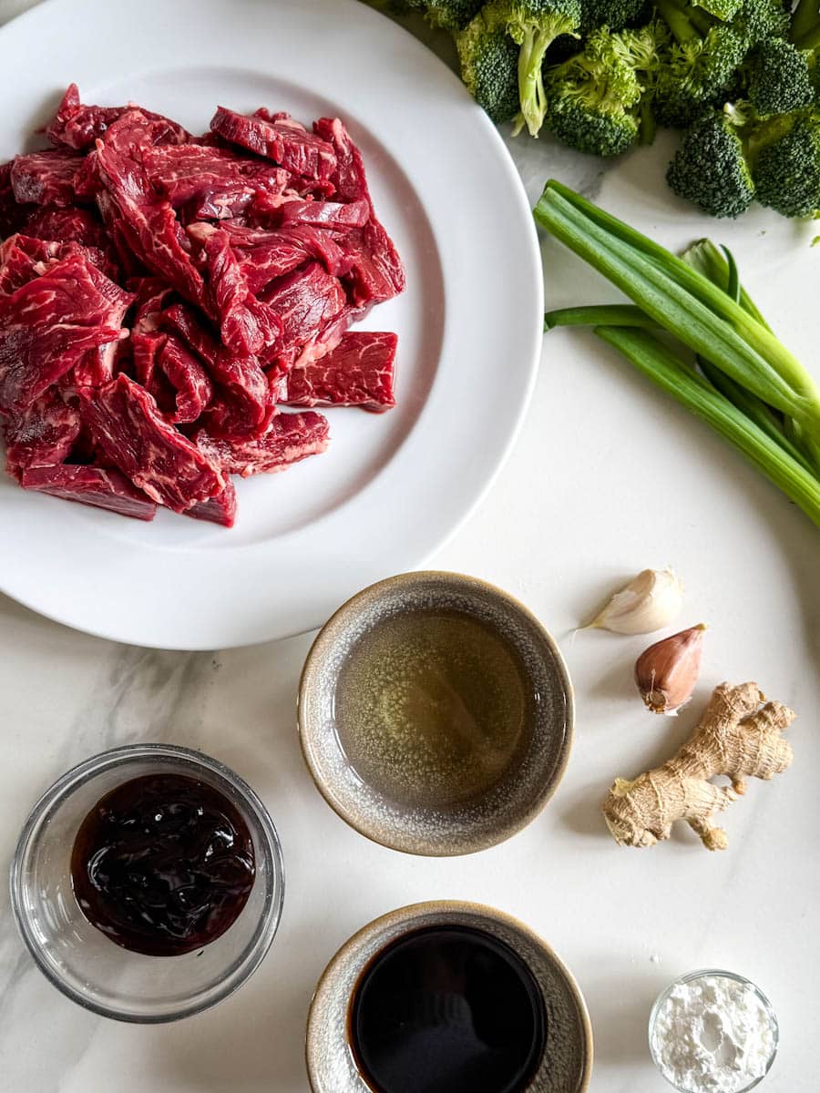 boeuf pour boeuf au brocoli avec sauce, brocoli, gingembre, ail sur comptoir marbré blanc