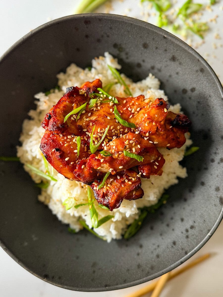 poulet gochujang dans un bol sur riz avec oignons verts