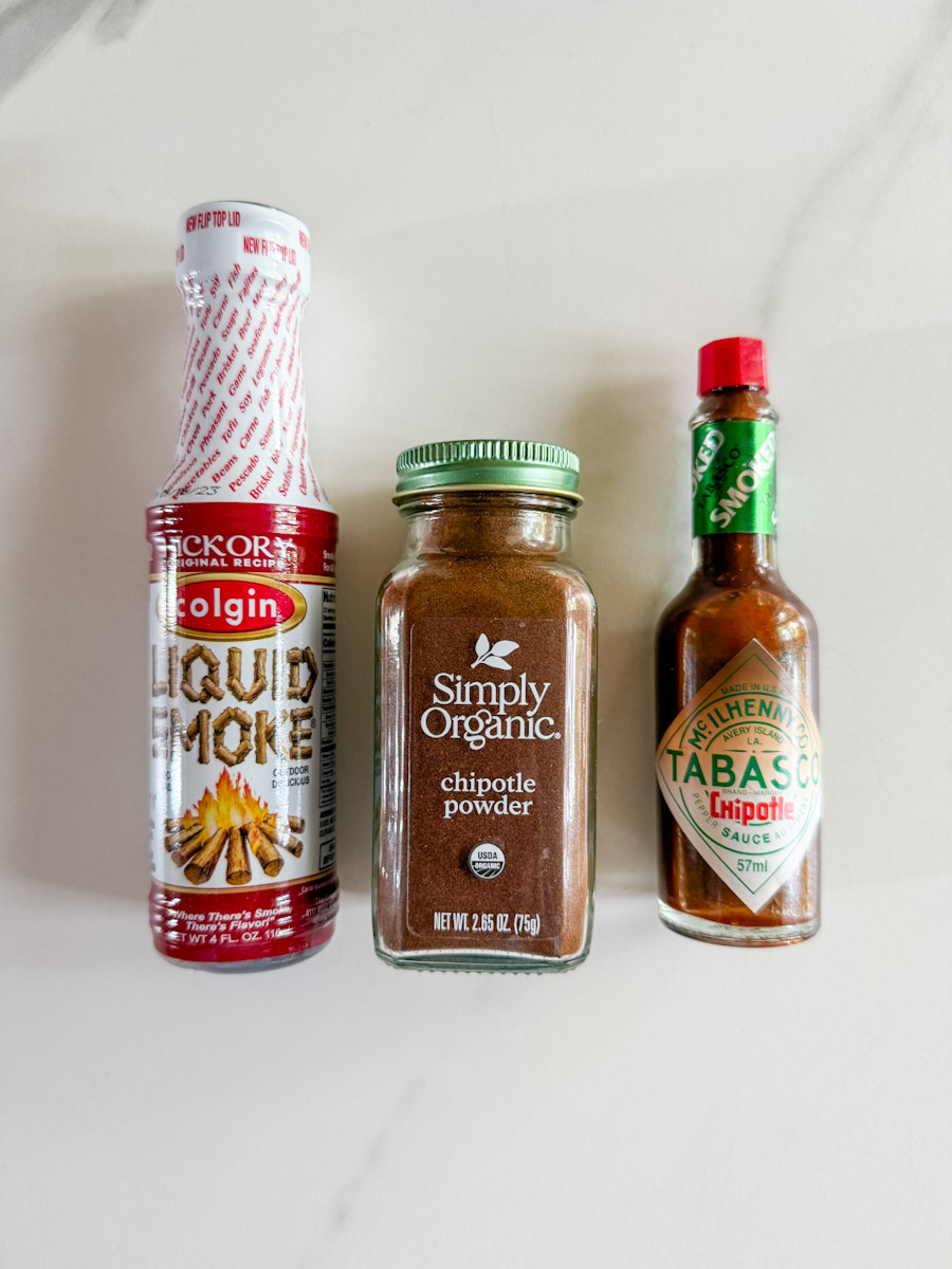bouteille de liquid smoke, pot d'épices chipotle simply organics et bouteille de sauce Tabasco Chipotle sur comptoir marbré blanc
