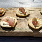 gravlax de maquereau sur petit blinis sur une planche de bois