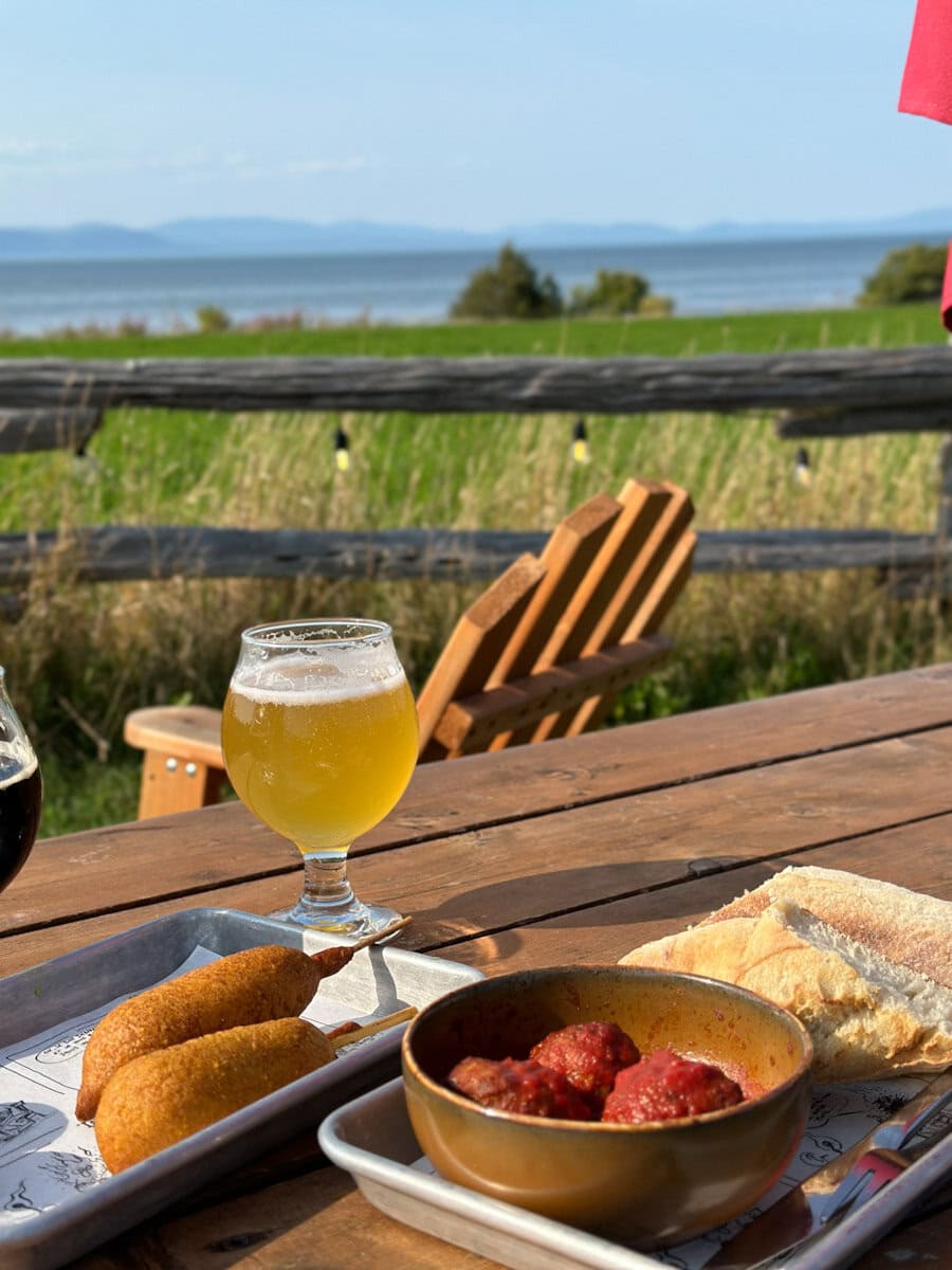 table en bois, biere, petits plats vue sur fleuve