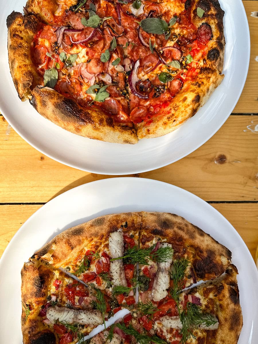 2 pizzas sur table en bois