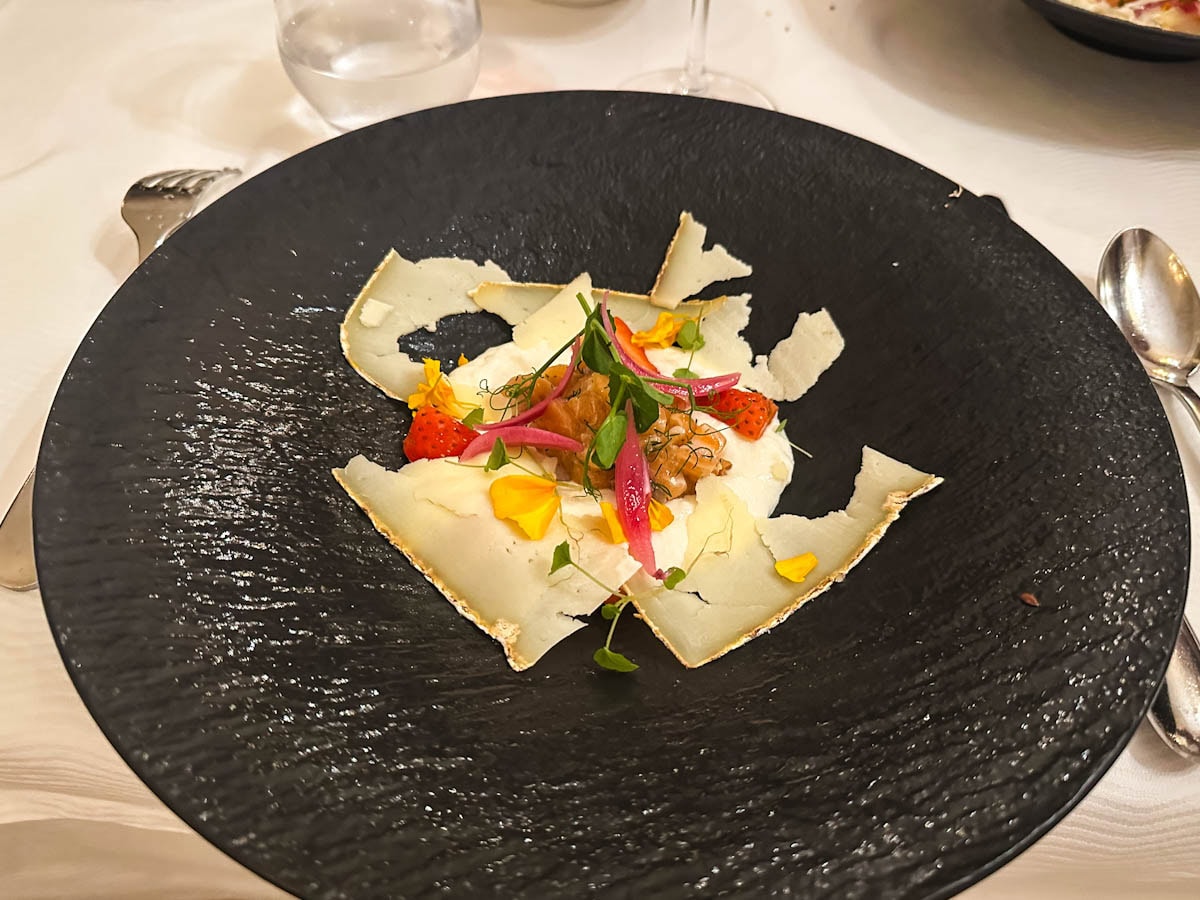 assiette noire avec petits légumes et fromage