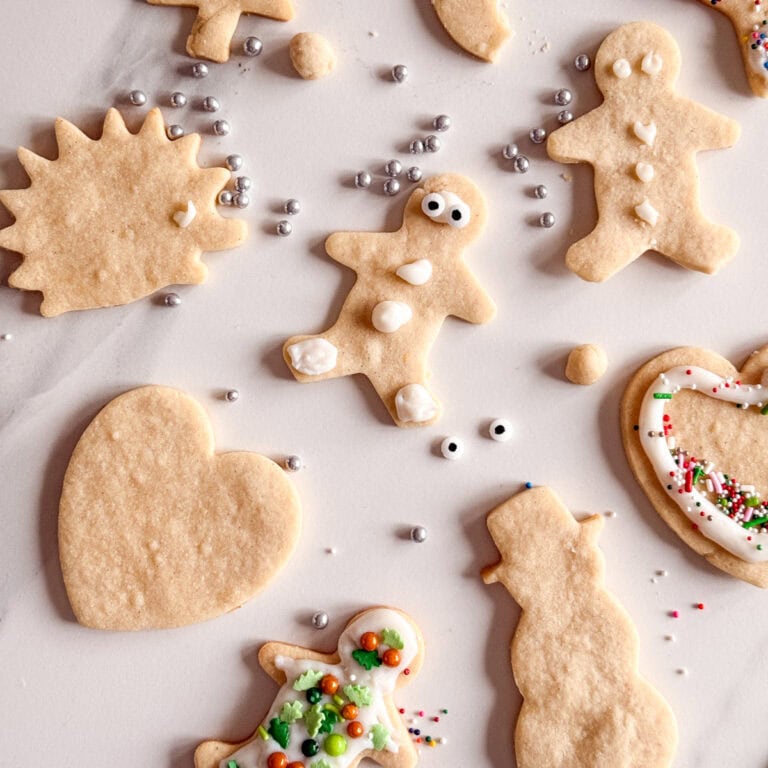 biscuits emporte pièce sur grille avec quelques-uns décorés de glacage blanc