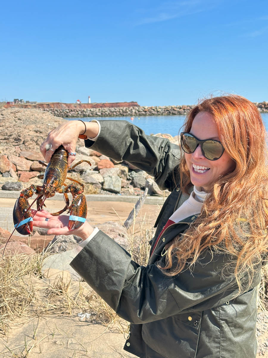 Manon Lapierre qui tient un homard aux Îles de la Madeleine