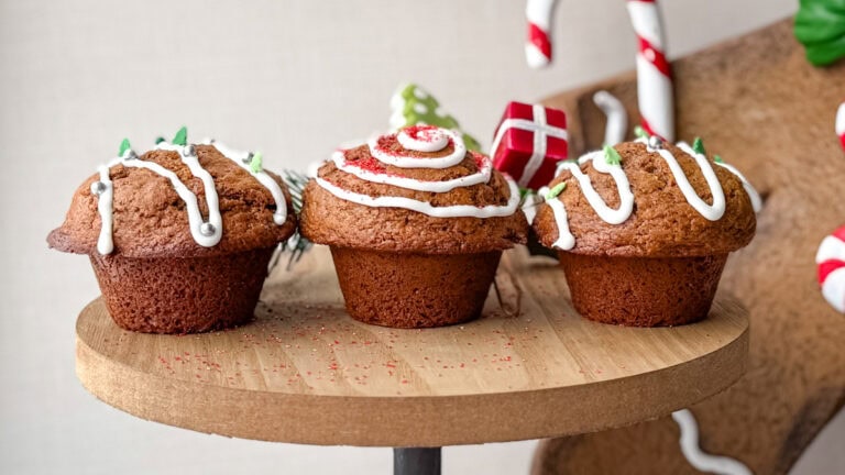 3 muffins pain d'épices sur planche de bois, décorés de glacage et sparkles de Noël