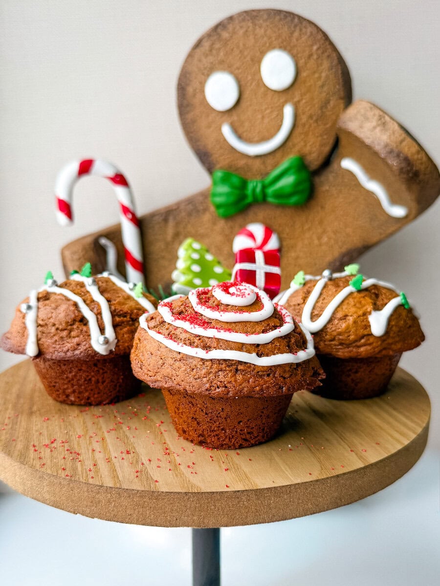 3 Muffins pain d'épices sur un présentoir avec bonhomme de pain d'épice géant en arrière plan