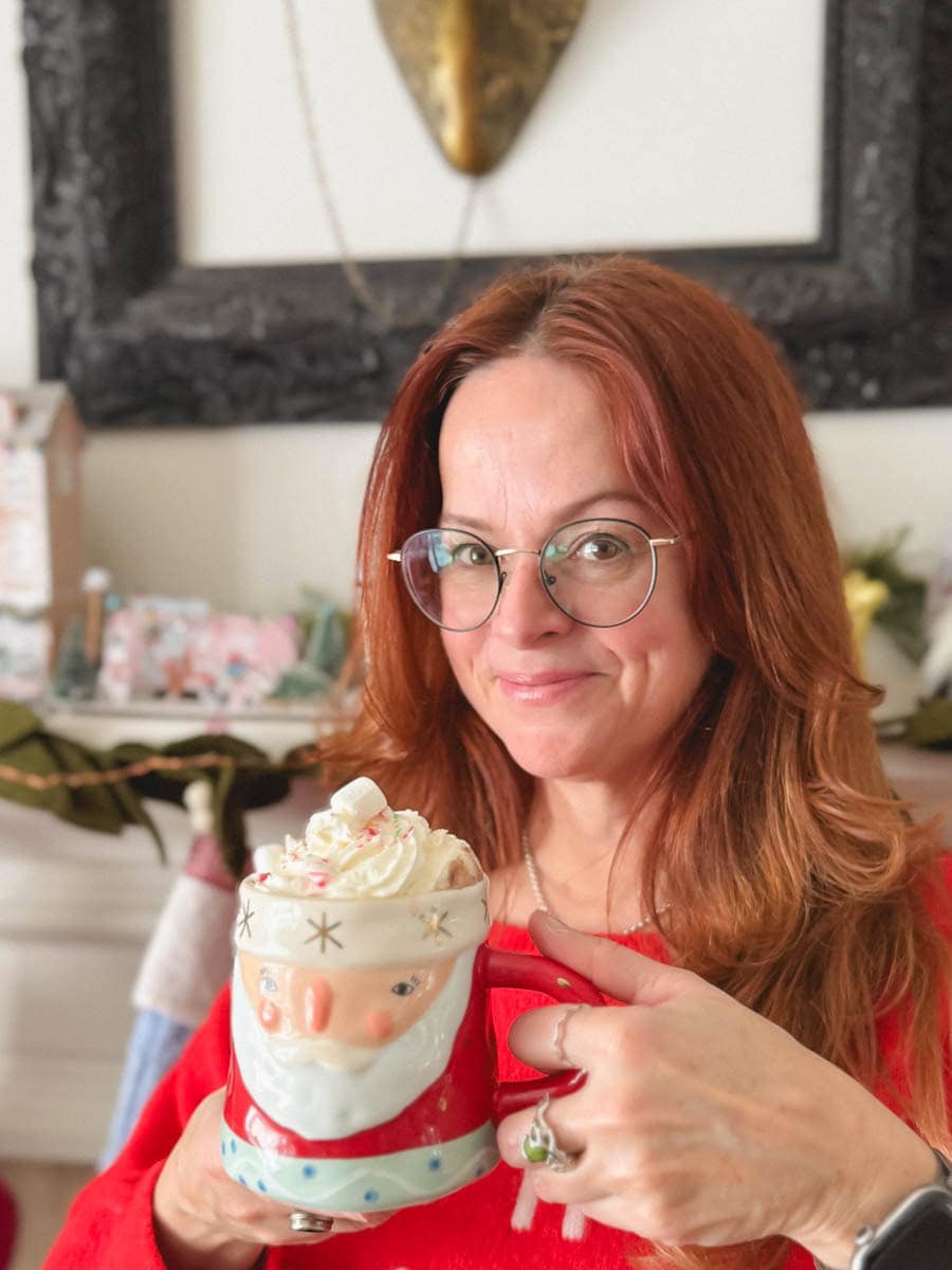 Manon Lapierre qui tient une tasse de ingrédients chocolat chaud gourmand devant le foyer
