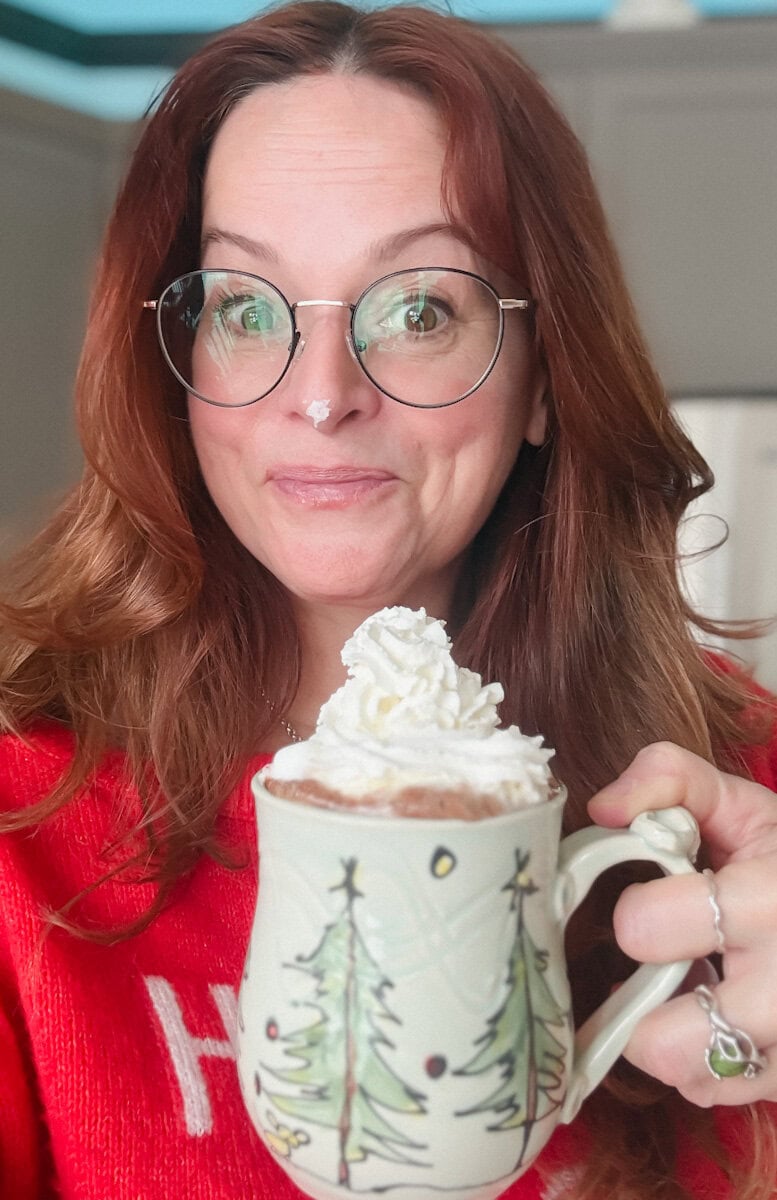Manon Lapierre avec tasse de chocolat chaud gourmand avec crème fouettée sur le nez