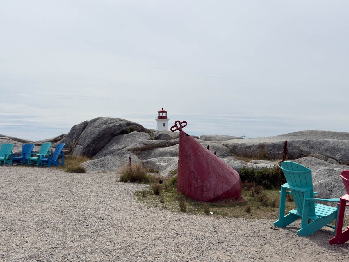 Phare de Peggy's Cove au loin avec chaises adirondack en premier plan