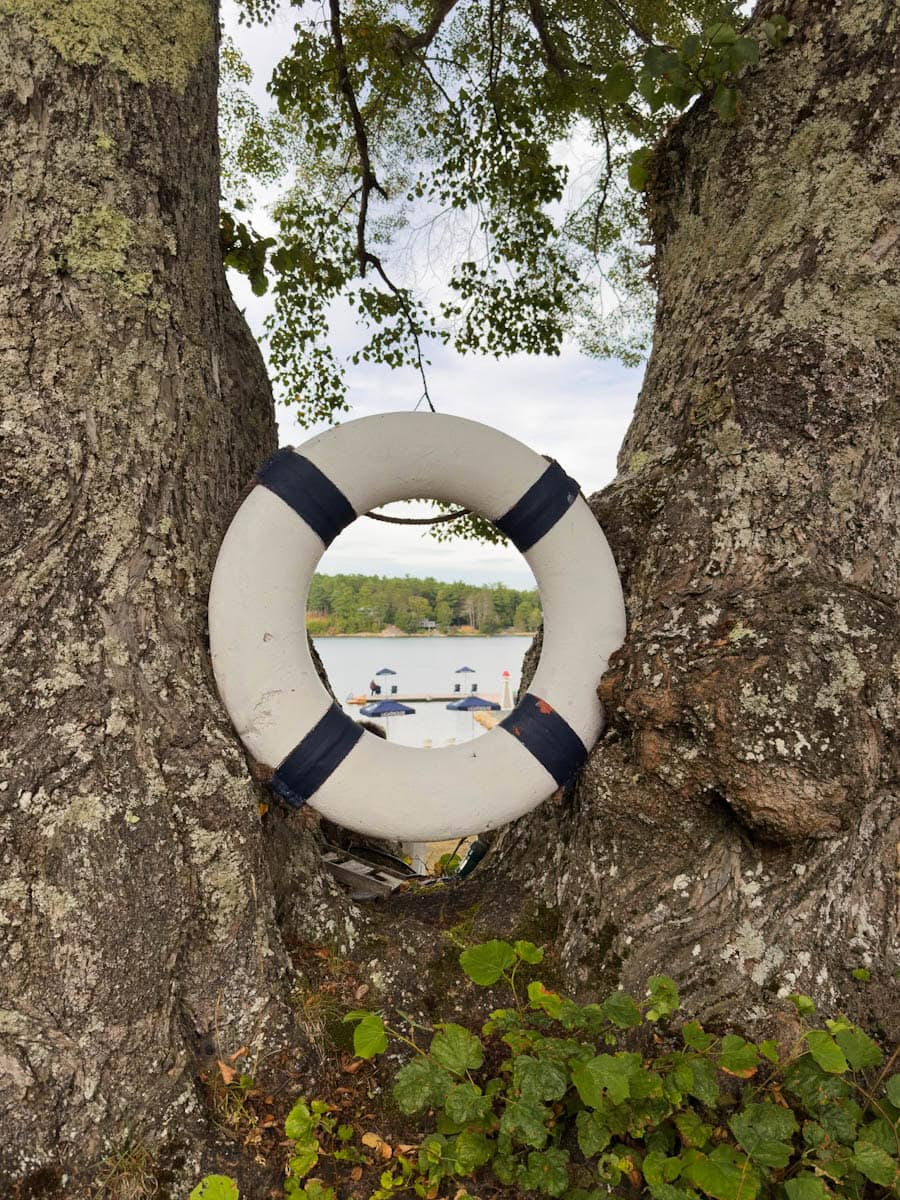 vue de la plage au travers d'une bouée décorative au Lightouse Motel and cottages NS