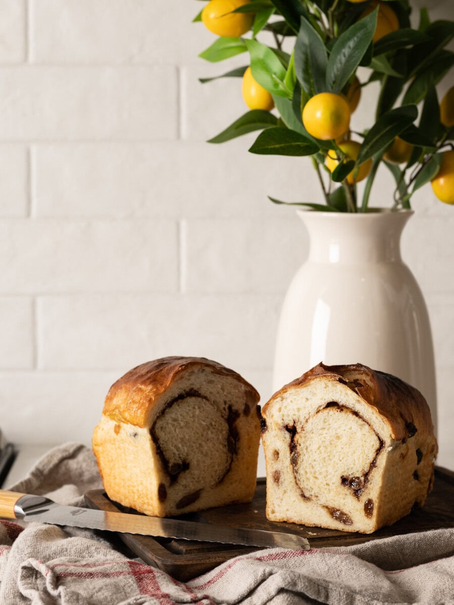 pain aux raisins avec tourbillon cannelle sur planche en bis devant pot de fleur