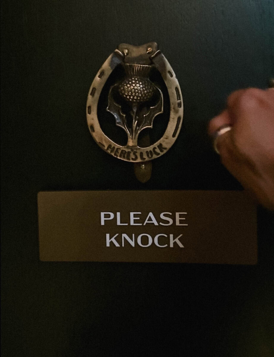 Main qui cogue à une porte mysterieuse du BKS Speakeasy at Muir Hotel Halifax