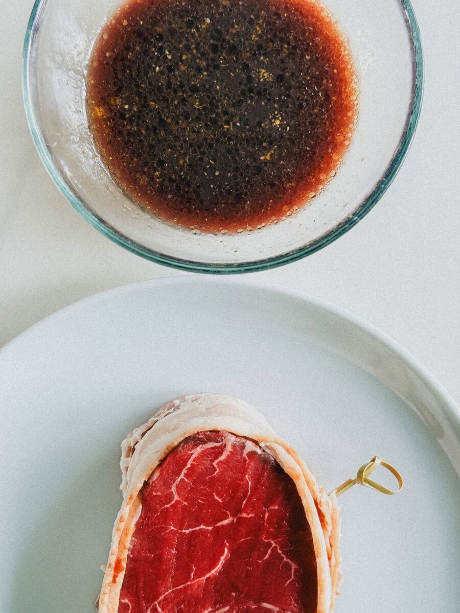 bol de marinade et tournedos dans une assiette blanche à côté