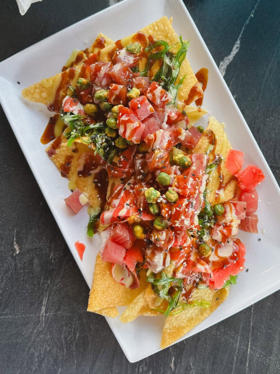 poke nachos dans une assiette rectangulaire blanche sur table marbrée noire