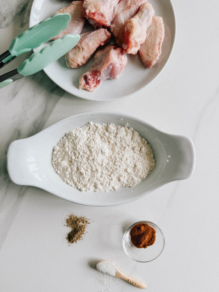 ailes de poulet, plat de farine, assaisonnements, sur comptoir blanc