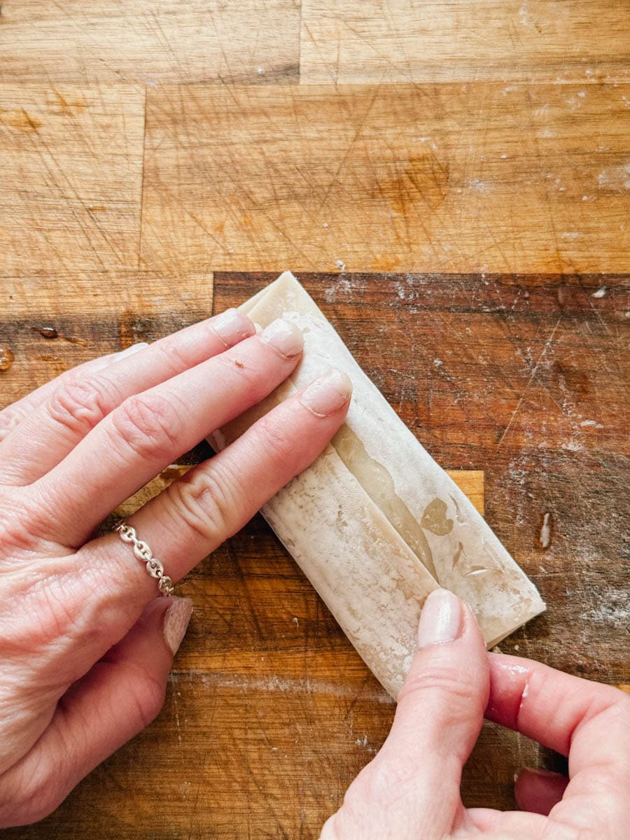 main qui replie la pochette de pâté impérial