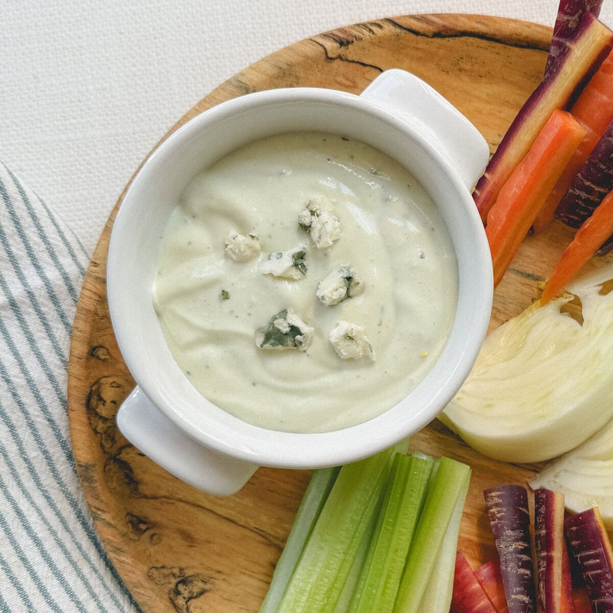 trempette au fromage bleu dans petit bol blanc sur assiette (en bois) de crudités; céleri, carrotte et fenouil