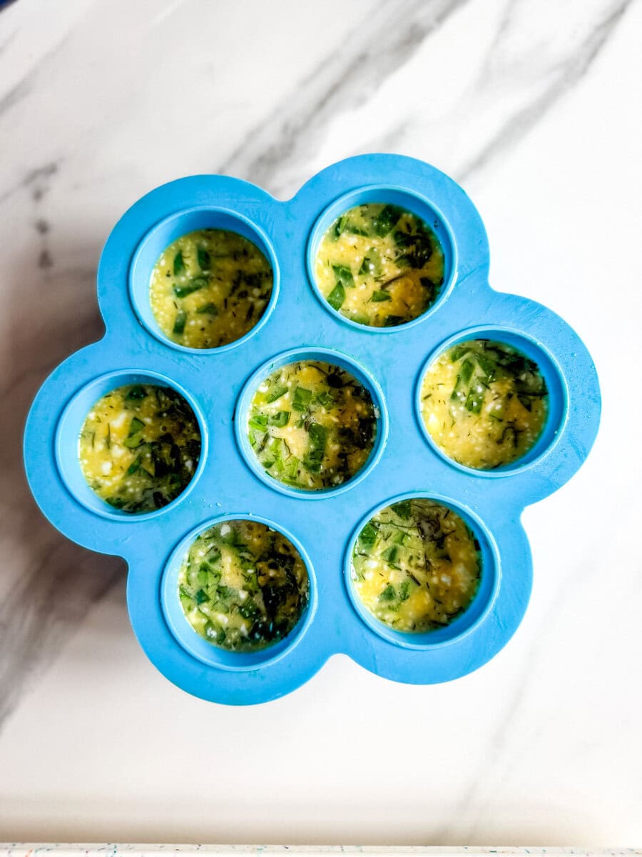 bouchées aux oeufs non cuites dans un moule en silicone bleu à 7 trous