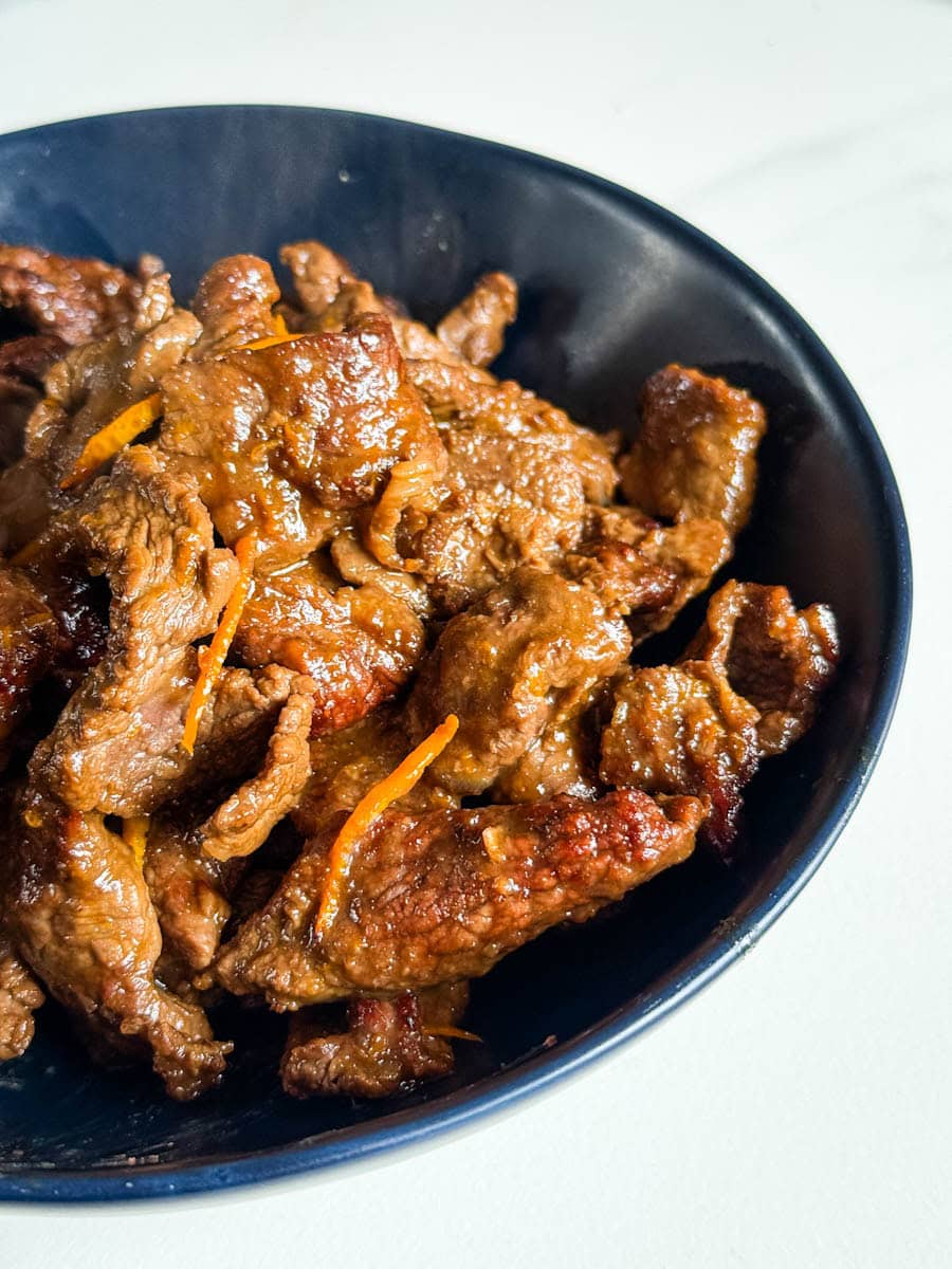 boeuf à l'orange dans sa sauce dans un bol bleu foncé
