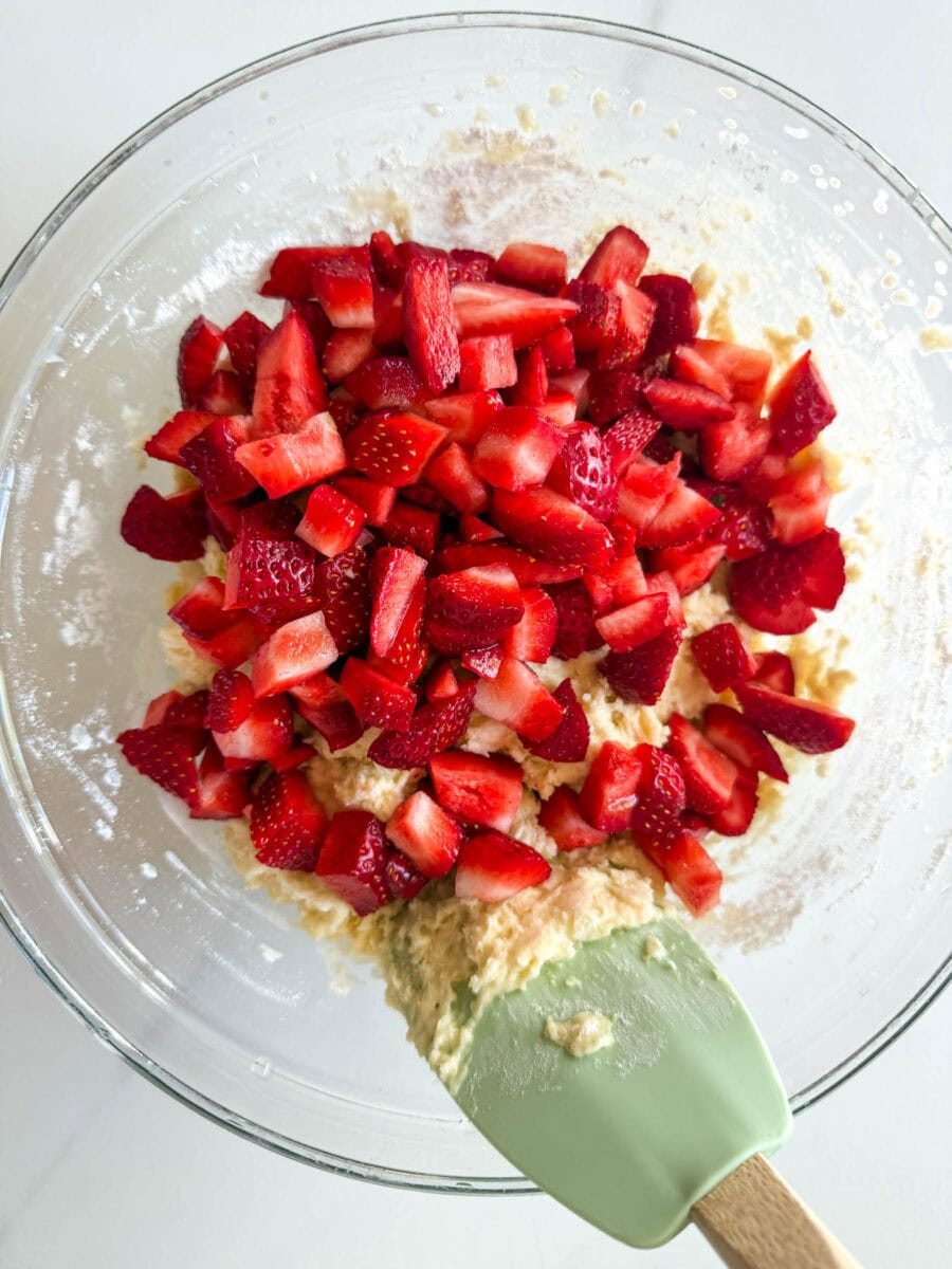 beaucoup de fraises en morceaux dans un bol de pâte à muffin