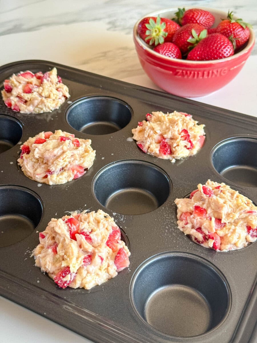 muffins aux fraises non cuits qui débordent des moules à muffin