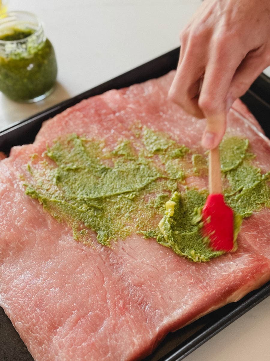 main qui étent du pesto avec maryse sur l'intérieur d'une longe de porc 
