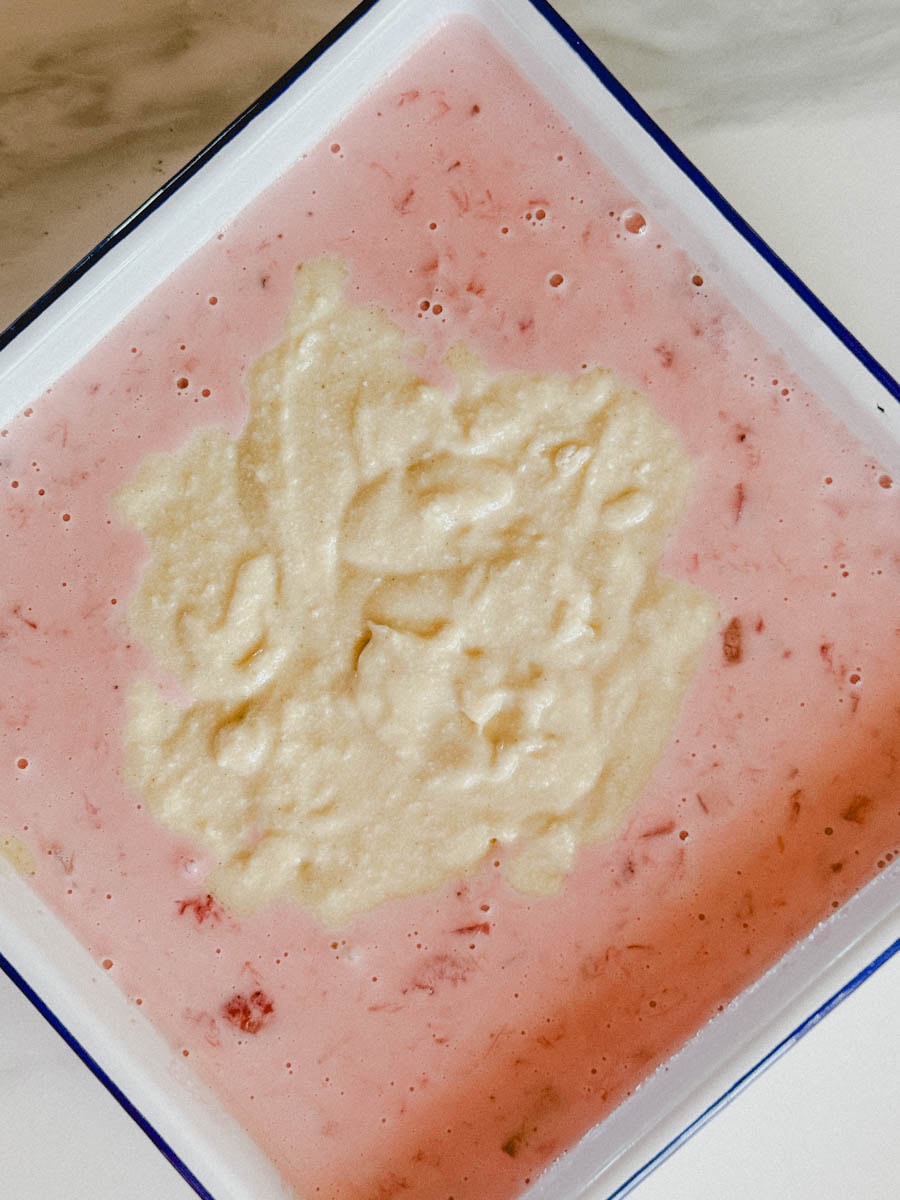 pâte à gateau non cuite qui baigne dans la sauce rose crèmeuse fraise et rhubarbe