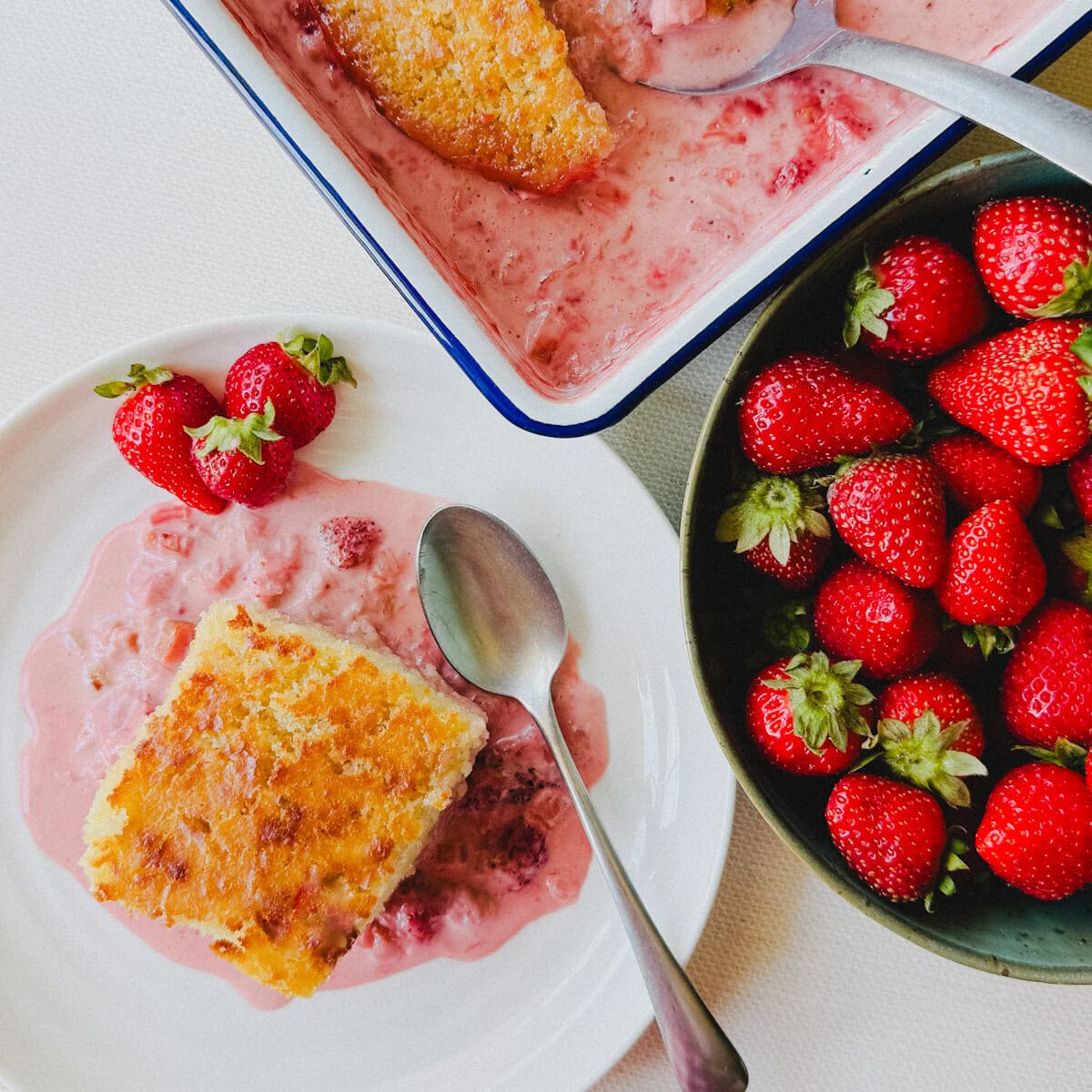 pouding fraise rhubarbe avec gros bol de fraises sur comptoir blanc