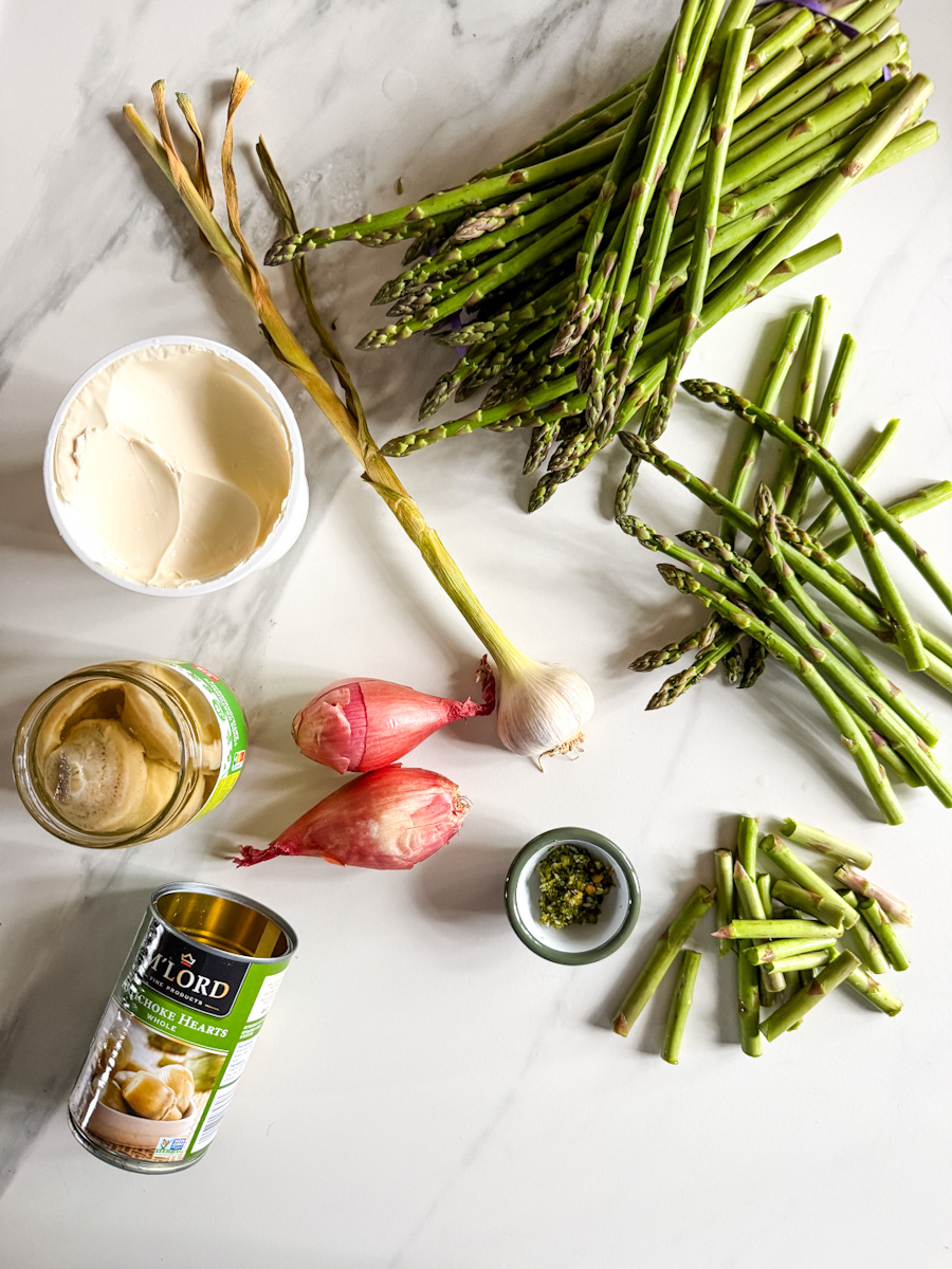 ingrédients sur comptoir blanc: asperges, queues d'asperges, artichauts, mascarpone, échalote, ail