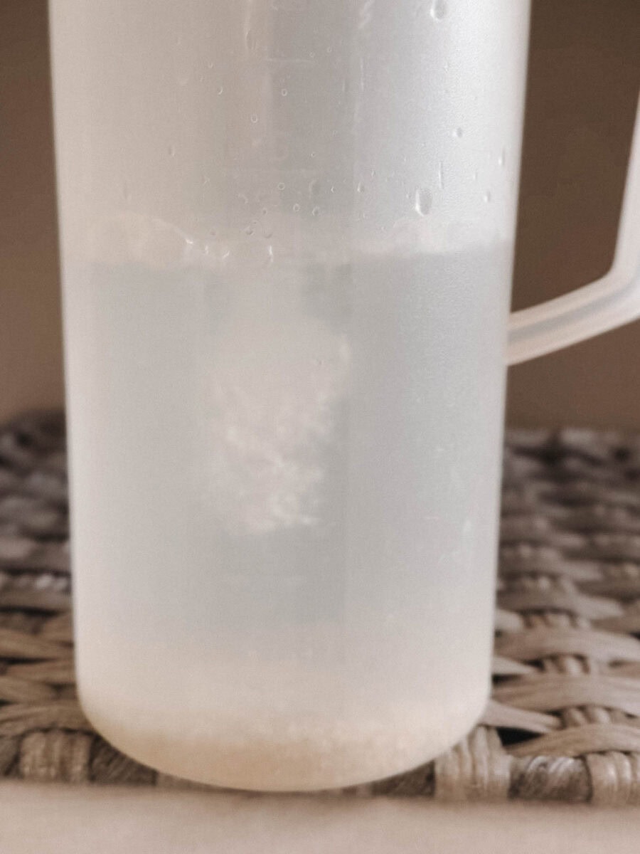 pichet d'eau en plastique avec sel au fond et eau qui entre