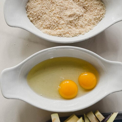 deux bols pour panure, bol avec 2 oeufs et bol avec chapelure et assiette avec lanières d'aubergine
