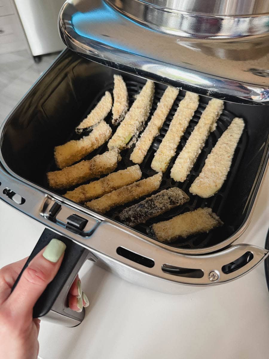 frites d'aubergine panées non cuite dans le panier du air fryer
